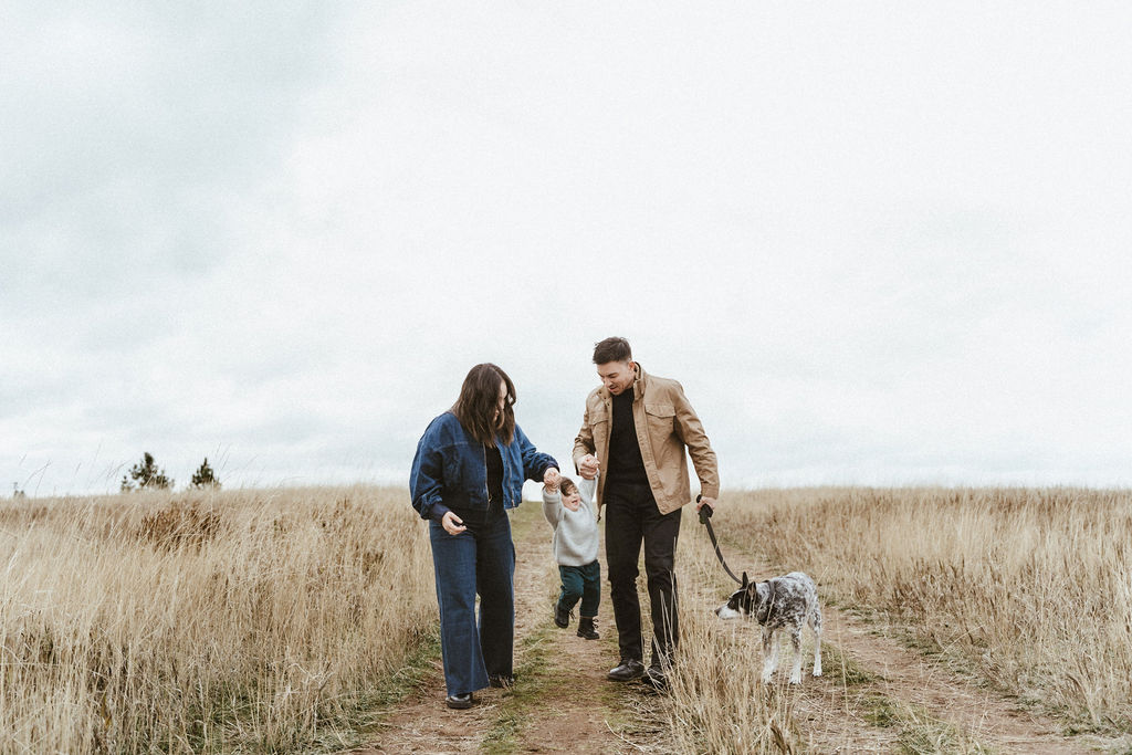 Mom and dad playing with their son and walking the family dog in a Spokane family photo session with Sophie Grace Photography