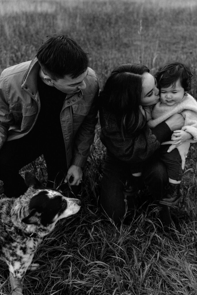A black and white photo of the family of 3 with their family dog in Spokane family photoshoot with Sophie Grace Photography