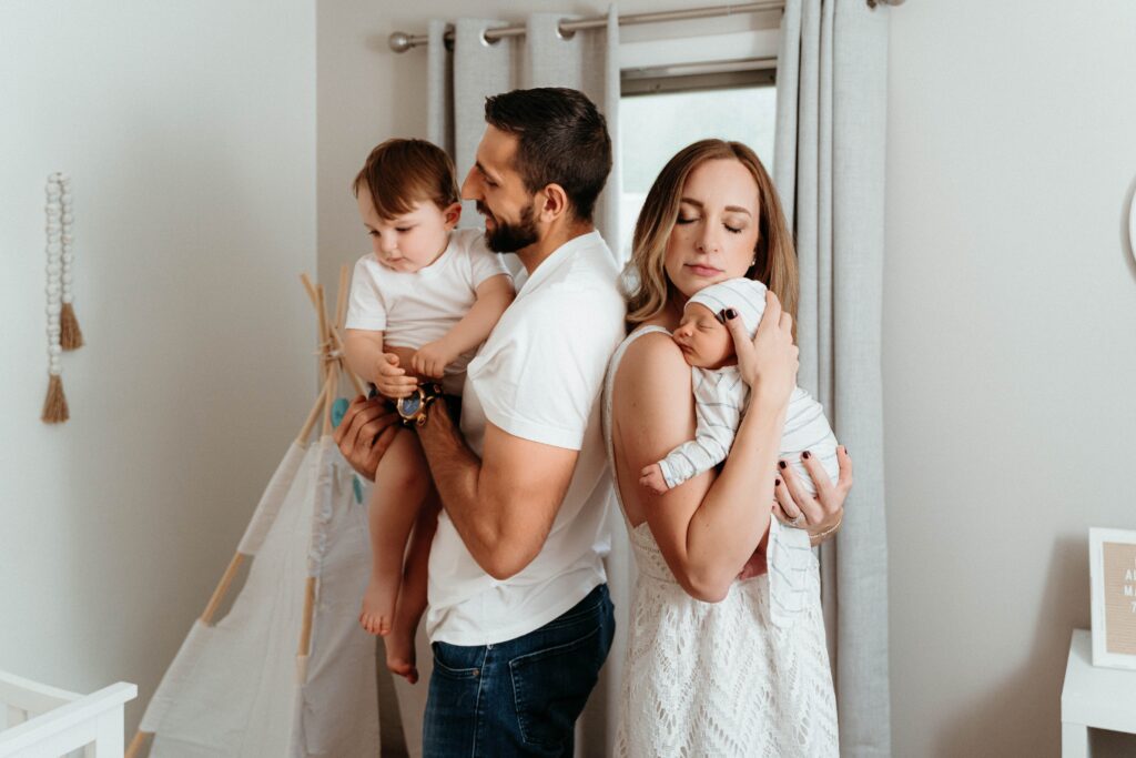 the whole family standing in the nursery soaking up the moments with sophie grace photography in a relaxing newborn session in spokane wa